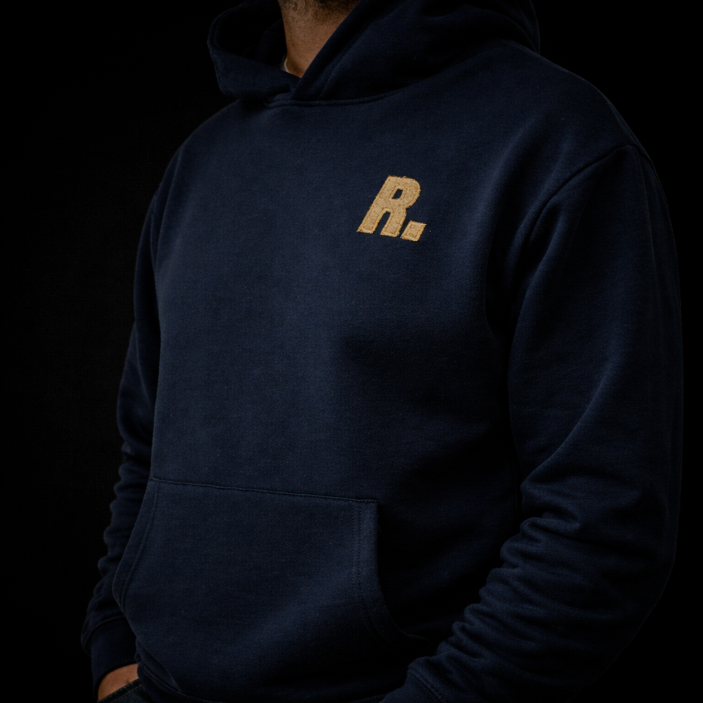 hoodie blauw in een donkere omgeving met gouden R logo op de borst